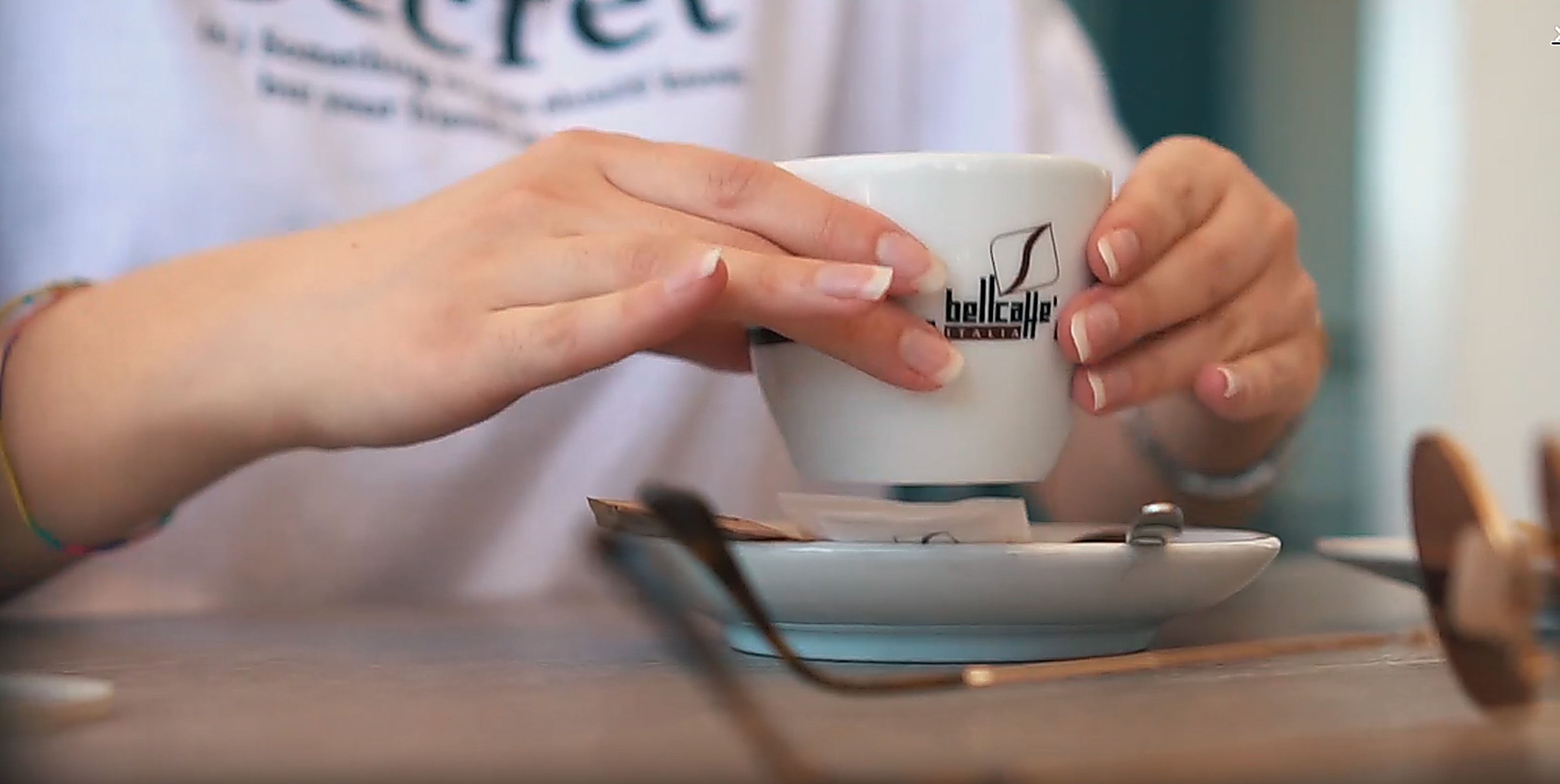 Ruce držící šálek Bellcaffe
